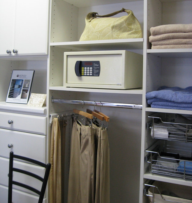 Мебельный сейф на полке в открытом шкафу.