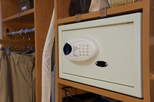 Мебельный сейф на полке в открытом шкафу.